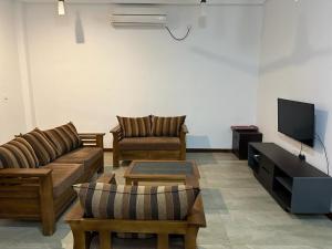亭可马里Trinco Waves的客厅配有两张沙发和一台电视机