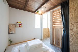 琴平町Kotori Coworking & Hostel Kotohira的一间卧室设有一张床和一个大窗户