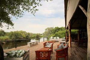 利文斯顿Zambezi Dusk的一个带椅子的木制甲板和一张沙发