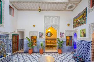 非斯Riad Rayhana的客厅的墙壁上铺有蓝色和白色的瓷砖。