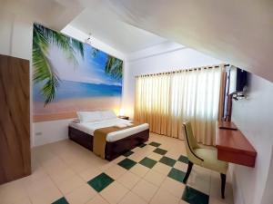长滩岛Castle Rock Apartelle的卧室配有一张带棕榈树壁画的床。