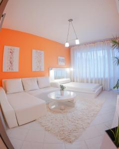瓦尔纳Alex Botique的客厅配有白色沙发和橙色墙壁