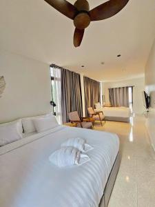 春蓬Calamint Residence Hotel ( คาลามิ้นท์)的卧室配有一张白色大床和吊扇