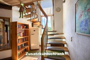 莱瑙Ferienhaus-Schwarzwald-Imbirkenweg-bei-Strassburg-Europapark-fuer-1-12-Personen的书架房子里的一个螺旋楼梯