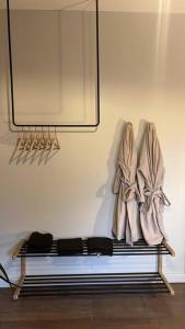 德班AfroJapandi Apartment的墙上的长凳,上面有大衣和镜子