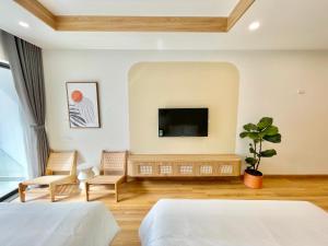 归仁TMS Quy Nhơn View Biển的一间卧室配有两张床和一台平面电视