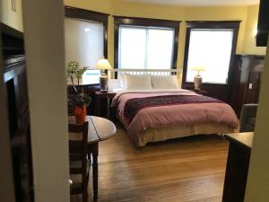 温哥华Vancouver guest house的一间卧室设有一张大床和两个窗户