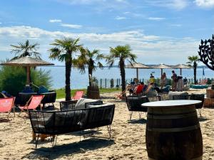 希尔克道夫Familienparadies mit TRAUM Meerblick am Strand mit großem Balkon - WLAN, Streaming, 2024 modernisiert的棕榈树海滩,沙滩上摆放着桌椅