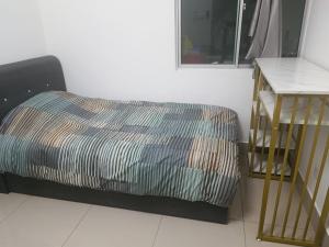 吉隆坡Razak City Centre KL SkyView 45th的一间卧室配有一张床,床头柜旁边设有一张桌子
