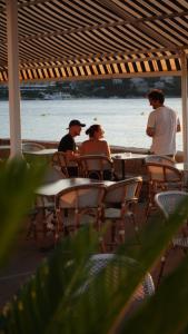 洛帕德Hotel Glavovic的一群坐在海滩桌子上的人