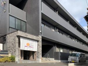 尾道市bHOTEL Yutori - Homestyle 1BR Apartment in Onomichi for 3 Ppl的停在前面的带货车的建筑