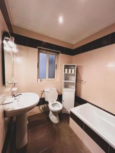彭布罗克Pembroke Parkside Maisonette的浴室配有盥洗盆、卫生间和浴缸。