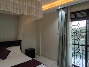 坎帕拉SHOAL Apartments, Mawanda Road的一间卧室设有一张床和一个大窗户