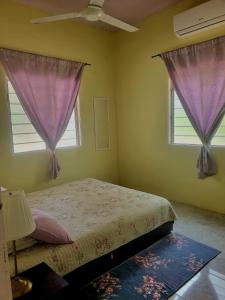 甘榜甘马挽Umar's Tiny House的一间卧室配有一张紫色窗帘的床和两个窗户