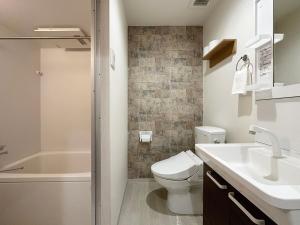 尾道市bHOTEL Yutori - Beautiful 1BR Apartment 6 mins walk to Station的浴室配有卫生间、盥洗盆和淋浴。