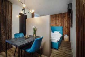 什平德莱鲁夫姆林Avenue Chalet的一间带桌子和蓝色椅子及一张床的用餐室