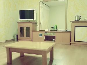 济州市大同酒店的客厅配有桌子和电视