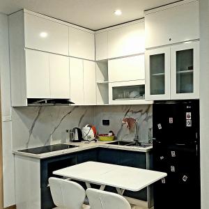 下龙湾Ha Long Bay View Studio的厨房配有白色橱柜和桌椅