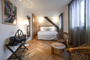 艾克斯莱班Grand Hôtel Du Parc - Teritoria的配有一张床和一把椅子的酒店客房