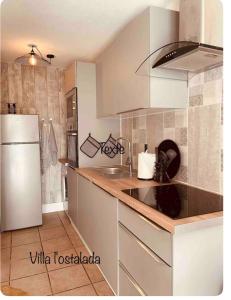 维亚斯Maison de vacances vias plage的厨房配有白色冰箱和水槽