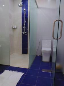 Phumĭ MréchKoh Ker Temples Garden Hotel and Restaurant的浴室配有淋浴和蓝色瓷砖卫生间。