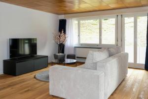 施皮茨Mariposa Spiez的客厅配有白色沙发和电视