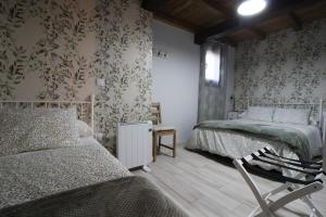 埃尔瓦Apartamentos Vedelejos的一间卧室设有两张床和花卉壁纸