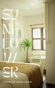 丽贝岛Sunflower Guesthouse and Animal Rescue - Koh Lipe的卧室里有一床,房间里还有植物
