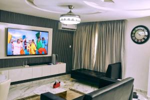 阿布贾aPogee Home的客厅的墙上配有电视
