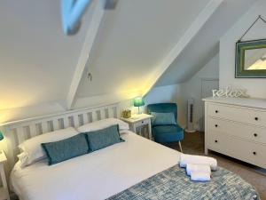 福伊Fowey River Views的卧室配有白色的床和蓝色椅子