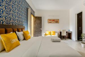 古尔冈Lime Tree Service Apartment Golf Course Road, Gurgaon的一间卧室配有一张带黄色枕头的大床