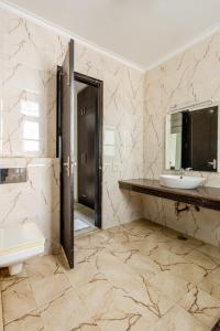 古尔冈Lime Tree Service Apartment Golf Course Road, Gurgaon的一间带水槽、卫生间和镜子的浴室