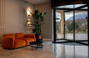 马诺卡尔扎蒂都耶托丽贝尔席多酒店的客厅配有橙色沙发和玻璃门