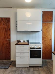 拉赫蒂Vintage Retreat的厨房配有白色橱柜和炉灶。