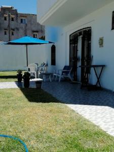 塔巴卡Villa Vue sur Mer的一个带蓝伞和桌椅的庭院