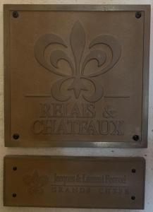 蒙彼利埃Hôtel Richer De Belleval - Relais & Châteaux的爬行动物和夹杂的亚利坚果诊所的标志