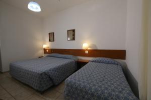 阿瓦雷Hotel Península的酒店客房设有两张床和两盏灯。