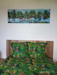 圣勒Chambre Vue sur Mer的一张带棕榈树绿色床罩的床