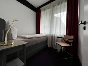 汉堡Neues Exclusives 2 Schlafzimmer Apartment Hamburg的一间卧室配有一张床、一张书桌和一个窗户。