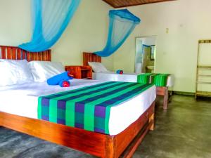 锡吉里亚Pride Rock Villa的卧室内的两张床,配有蓝色和绿色的窗帘