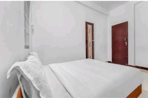 哥印拜陀Hotel Crown Tower的红色门的房间的一张白色的床