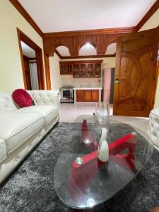 HigueyApartaHotel El Bonao的客厅配有白色沙发和玻璃桌