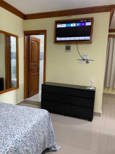 HigueyApartaHotel El Bonao的卧室配有一张床,墙上配有电视。