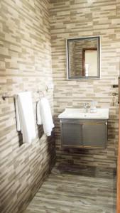 卢萨卡KKI Serviced Apartments的一间带水槽和镜子的浴室