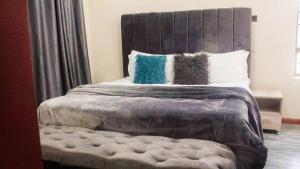 卢萨卡KKI Serviced Apartments的一间卧室配有一张大床和两个枕头