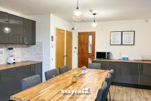 曼彻斯特Stylish 10 Bedrm House, Fast Wifi, Free Parking的厨房以及带木桌的用餐室。