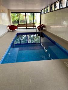 戈亚斯州上帕莱索Pousada Flor de Anis的大楼内的一个蓝色海水游泳池