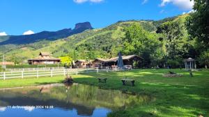 圣本图-杜萨普卡伊Chalés Poly的一座公园,公园里有一个池塘,建筑和山