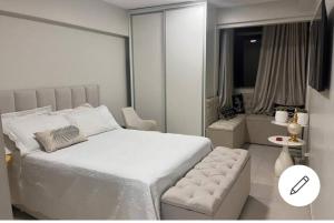 巴西利亚ESPAÇO ACONCHEGANTE NO SUDOESTE的卧室配有一张白色大床和一把椅子