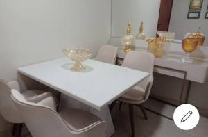 巴西利亚ESPAÇO ACONCHEGANTE NO SUDOESTE的白色的餐桌、白色的椅子和白色的桌子